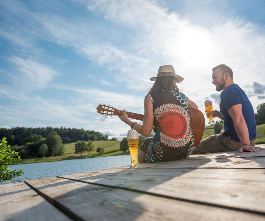 Paar mit Gitarre und Graf Arco auf Steg