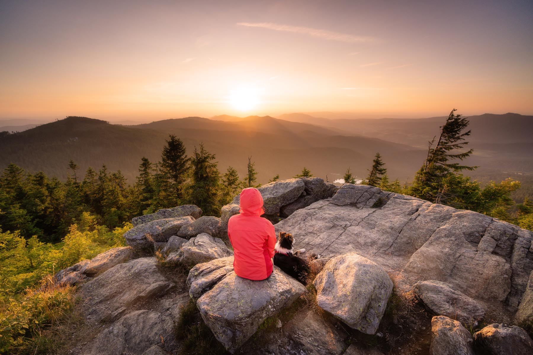 Person in roter Jacke auf Felsen